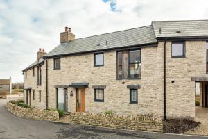 an old brick house with a stone wall at Luxury property with spa access on a nature reserve Hambury Cottage BV22 in Warmwell