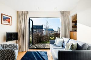 uma sala de estar com um sofá e uma grande janela em Luxury property with spa access on a nature reserve Hambury Cottage BV22 em Warmwell