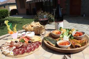 a table with two plates of food and a glass of wine at Cascina Angelina in Casteggio