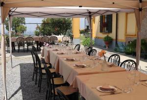 una mesa larga con mesas y sillas bajo una sombrilla en Cascina Angelina, en Casteggio