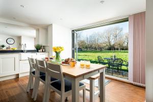 a kitchen and dining room with a table and chairs at Lakeside property with spa access on a nature reserve Ruby Cottage MV04 in Somerford Keynes