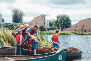 a group of people in a boat on the water at Lakeside property with spa access on a nature reserve Ruby Cottage MV04 in Somerford Keynes