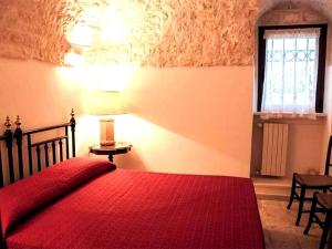 ein Schlafzimmer mit einem roten Bett und einem Fenster in der Unterkunft Casale Romanazzi Pool & Nature in Monopoli