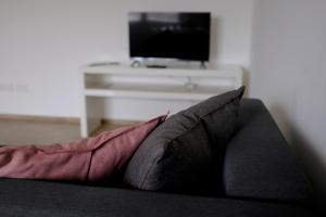 kanapa z poduszkami i telewizor w salonie w obiekcie M&Mapartments w mieście Monopoli