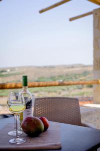 a bottle of wine and some apples on a table at Alagni Cretan Resort in Stíronas