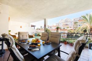 a dining room with a table and chairs on a balcony at NEW ROYAL TORREQUEBRADA 2 Pets friendly & ideal for family groups in Benalmádena