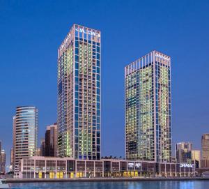 deux grands bâtiments dans une ville à côté de l'eau dans l'établissement New Aparthotel Prive, à Dubaï