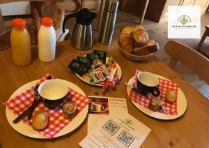 アンネヴィルにあるAppart Hôtel Le Pin Sylvestreの食べ物と牛乳の2皿付きテーブル