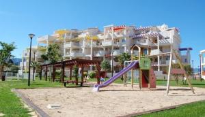 une aire de jeux devant un grand immeuble d'appartements dans l'établissement Coll Verd Apartment, à Dénia 4 autres photos