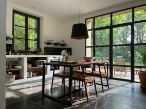 a kitchen with a table and chairs and windows at Le Pavillon Du Regisseur in Val-de-Dagne +15 photos