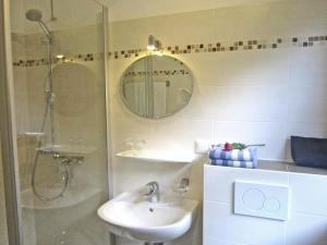 a bathroom with a shower and a sink and a mirror at Bauernhof Ertlhof in Sachrang