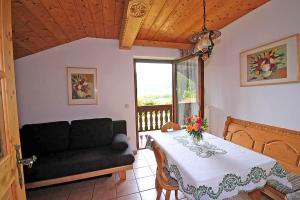 a living room with a table and a couch at Bauernhof Ertlhof in Sachrang