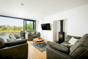 a living room with two couches and a fireplace at Luxury lakeside property with spa access ML44 in Cirencester