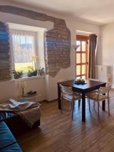 una sala da pranzo con tavolo, sedie e parete in pietra di Appartamento a Costa di Folgaria a Folgaria