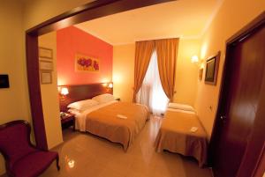 a hotel room with two beds and a window at Hotel San Paolo in Manduria