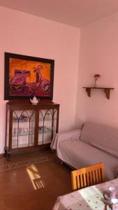 a living room with a bed and a painting on the wall at ROME SWEET ROME - close to line A San Giovanni in Rome
