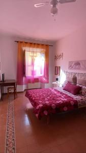 a bedroom with a bed with pink sheets and a window at ROME SWEET ROME - close to line A San Giovanni in Rome