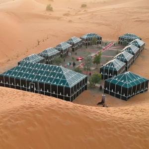 uma vista aérea de edifícios verdes no deserto em djou luxury desert camp em Merzouga