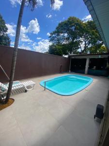 a swimming pool on a patio with a palm tree at Casa do Sussego in Foz do Iguaçu