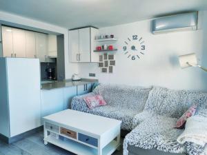 salon z kanapą i kuchnią w obiekcie Bermudas apartamento con piscina y garaje en Benidorm w mieście Benidorm