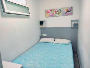 małą sypialnię z niebieskim łóżkiem w pokoju w obiekcie Bermudas apartamento con piscina y garaje en Benidorm w mieście Benidorm +5 zdjęć