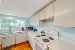 a kitchen with white cabinets and a stove top oven at Anchor Court Views in Lincoln City