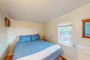 een slaapkamer met een blauw bed en een raam bij Anchor Court Views in Lincoln City