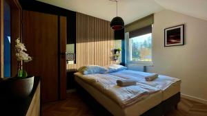 a bedroom with a bed with two towels on it at Apartamenty Karkonoska Dolina in Staniszów