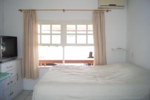1 dormitorio con cama y ventana grande en Casa pé na areia Ponta do Papagaio, en Palhoça