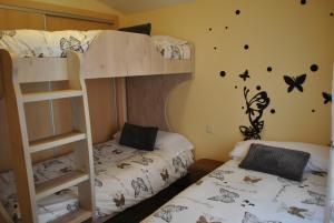 - 2 lits superposés dans un dortoir avec des papillons sur le mur dans l'établissement Viviendas de uso turisitco Dulcinea, à Ventas con Peña Aguilera