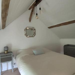 a bedroom with a white bed and a table at Eden Koï in Conteville
