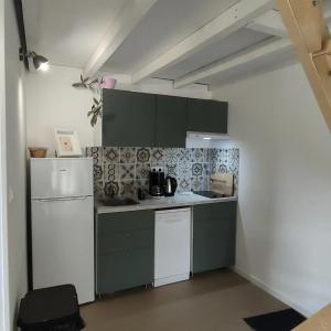 a kitchen with a white refrigerator and a stove at Eden Koï in Conteville +10 photos