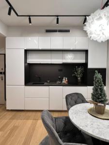 uma cozinha com armários brancos e uma mesa com cadeiras em SDesign Luxury Zagreb apartment em Zagreb