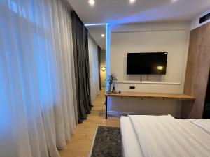 a hotel room with a bed and a flat screen tv at SDesign Luxury Zagreb apartment in Zagreb