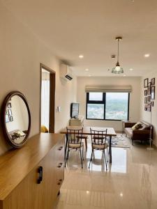 uma cozinha e sala de estar com uma mesa e um espelho em Stellar's Haven near High Tech Park with Stunning View and POOL em Gò Công