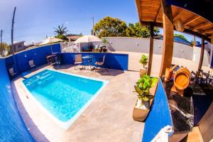 a swimming pool with a blue wall and a table at Pousada SDOIS in Imbé