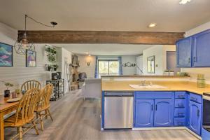 cocina con armarios azules, mesa y sillas en Grand Lake Condo with Views Less Than 2 Mi to Town!, en Grand Lake