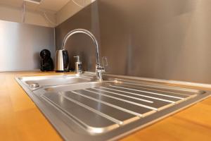 a stainless steel kitchen sink with a faucet at Cabana & La Cascade in Mâcon
