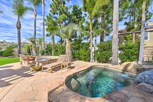 un patio trasero con piscina, banco y palmeras en Stunning Carlsbad Home with Patio and Private Hot Tub!, en Carlsbad