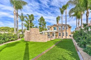 una casa con palmeras frente a un patio en Stunning Carlsbad Gem with Fire Pit and Hot Tub! en Carlsbad