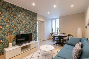 a living room with a blue couch and a tv at Cabana & La Cascade in Mâcon