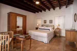 1 dormitorio con 1 cama, mesa y sillas en Posada Manuel Lobo, en Colonia del Sacramento