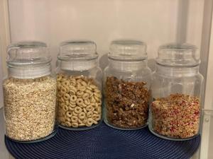 a shelf with four glass jars filled with different types of nuts at Bed & Breakfast Donji Grad in Zagreb