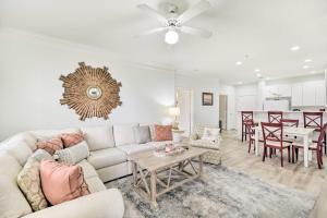 a living room with a couch and a table at Calabash Condo with Patio and Golf Course Views! in Calabash