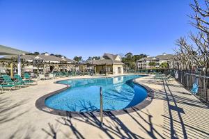 a swimming pool at a resort with chairs and trees at Calabash Condo with Patio and Golf Course Views! in Calabash