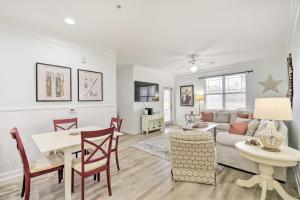 a living room and dining room with a table and a couch at Calabash Condo with Patio and Golf Course Views! in Calabash