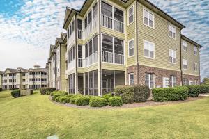 a large apartment building with a lawn in front of it at Calabash Condo with Patio and Golf Course Views! in Calabash