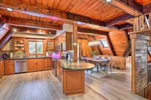 a kitchen with wooden cabinets and a table in it at Rustic LaFayette A-Frame Cabin with Game Room! 