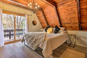 a bedroom with a bed and a large window at Rustic LaFayette A-Frame Cabin with Game Room! 