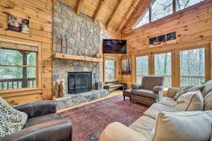 a living room with a stone fireplace in a cabin at Walk to Golfing Grand Maggie Valley Cabin! in Maggie Valley